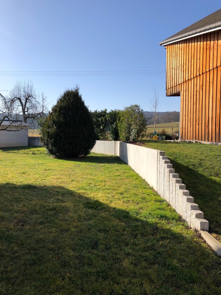 Réalisation d&rsquo;un mur de soutènement en béton préfabriqué en L et palissades en granit gris clair à Raedersdorf proche de Ferrette